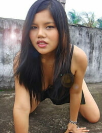Filipino model in a ebon clothing shows her uncovered legs during modeling non unclothed