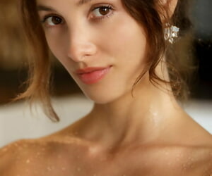 Beautiful teen Calypso models totally naked in a bathtub with her hair up