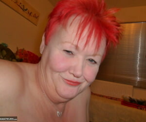 Doyenne redhead Valgasmic Bald exposes her breasts by means of self shot thing