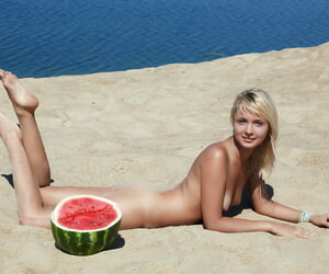 Adorable blonde Lada displays her well done shaved pussy on a grainy beach