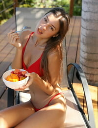 Russian babe in a red bikini Melena Tara undresses & poses while eating fruits