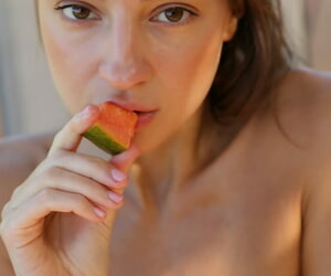 Russian babe in a red bikini Melena Tara undresses & poses while gnawing away fruits