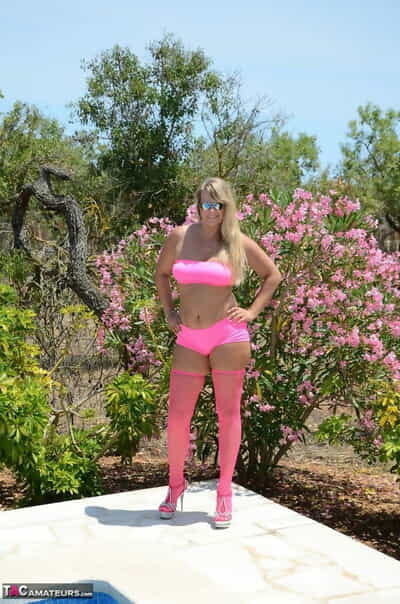 mais 30 loira Doce Susi fica nu ao lado de um piscina no cor-de-rosa meias e tons