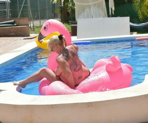 Older tattooed blonde Melody goes topless on an inflatable in a swimming pool