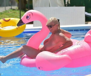 Older tattooed blonde Melody goes topless on an inflatable in a swimming pool
