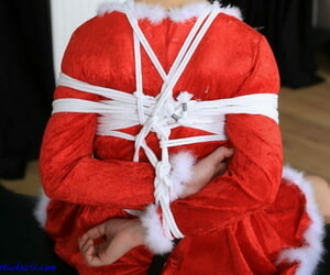 Barefoot girl is tied up and ball gagged while outfitted in Xmas suit