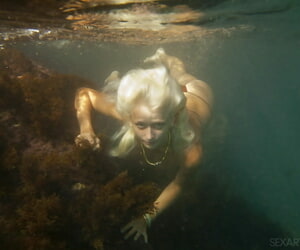 Ukrainian stunner Nika N swims in-ground for divest posing inside a cave