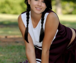 Dark haired girl Shyla Jennings lifts up her cheerleader skirt on a lawn