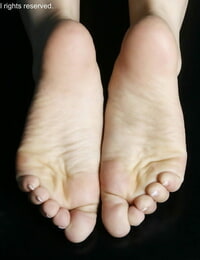 कोकेशियान महिला खेल एक जोड़ी के पैर की अंगुली के छल्ले पर के एक ही समय के रूप में दिखा रहा है उसके मनोहर पैर