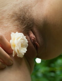 Appealing fairy Dolly fondles her unshaved youthful wet crack with a white rose on a lawn