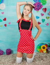 Charming young girl shows her tan lined body in long socks and pigtails
