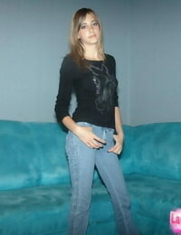 Elegant teen fairy-haired in tense jeans strikes seductive standing to show off her gazoo