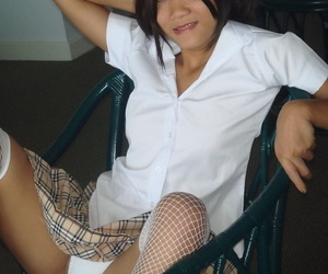 Cute Asian teen shows off her bald pussy in mesh stockings and pigtails