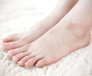 jong Aziatische japans meisje in kousen uitkleden ongeveer sleep blazen haar ongelakt tenen