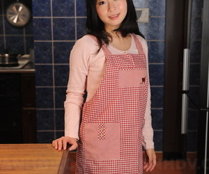Japanese housewife with a pretty face poses non nude in her kitchen