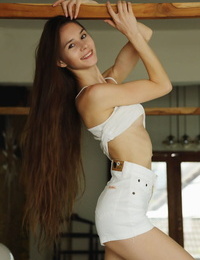 Long haired teen Leona Mia accentuates her tight ass and bald slit once naked