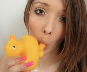 Amateur model Buffy holds a rubber duck to the fullest exhibiting a resemblance her giving breasts