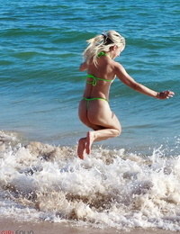 ouro cabelos jovem Chloe aparelhos passos admira o oceano surf vestindo um acanhado Biquini