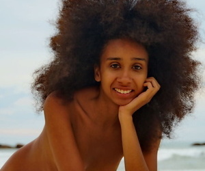Slim black teen with big hair Isadora touts her hot ass in the nude on a beach