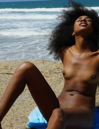 Brown beauty with a major fro Isadora shows her shiny on top gentile and sticky wazoo by the ocean