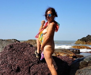 Mature amateur Diana Ananta is joined on the beach by her nudist friends