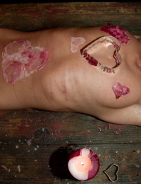 A gagged and restrained Cecilia Vegais is overspread in heart shaped wax