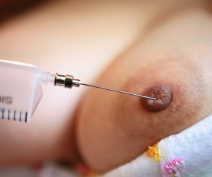 Kinky Japanese nurse Namie Koshino pokes her naked body parts with a needle