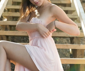 Nice teen Oxana Chic poses her tan lined body on wooden stairs of hiking trail