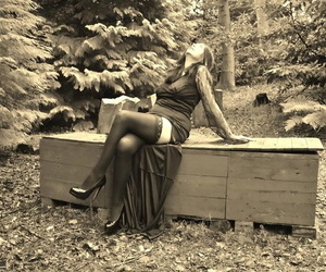 Goth girl Barby Slut bares her big tits and twat atop a casket in the woods