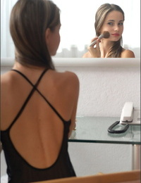 Beautiful solo girl admires her perfect ass in a mirror on the wall