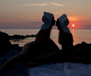 Teen lesbians Milena D & Nika N licks twats on a beach as the sun sets