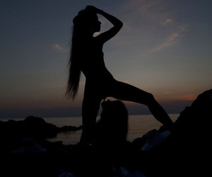 Teen lesbians Milena D & Nika N licks twats on a beach as the sun sets