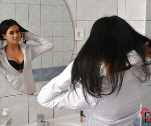 Tempting brunette cutie performs a reverse striptease in the bathroom