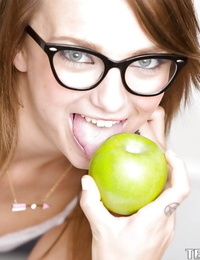 Smiley schoolgirl in glasses with compact body obtains in nature\'s garb in the classroom