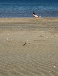 Beach beauty Emily sunbathing naked on the sand spreading long legs wide open
