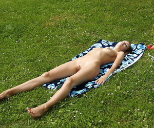 Lusty teenage cutie taking off her bikini and toying her slit outdoor