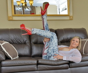 Older woman foreigner Canada strips back her red pumps aloft a leather couch