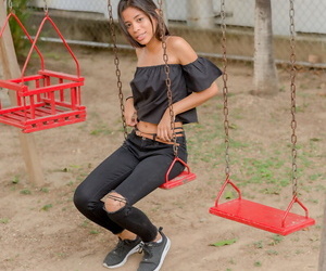 Smiley caldo glamour Ragazza Karin Torres cercando sexy in strappato jeans su un swing