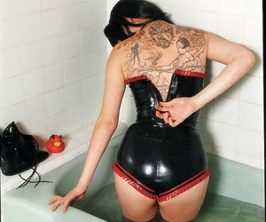 Playful asian babe slipping off her sexy latex outfit in the bathroom