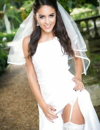 Not long ago married bride Carolina Abril posing outdoors in wedding costume