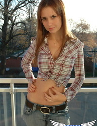 Redheaded country girl models non nude in tied up shirt and denim jeans