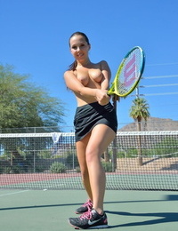 tiener tennis speler disrobes op hof vooruit van invoegen racket druk Rond in ontuchtige gespleten