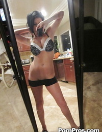 escuro cabelos Babe loni evans snaps selfies enquanto striptease no a barriga. de espelho