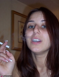 Totally naked girl Lexxxi sits on her bed while smoking a cigarette