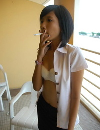 juvenil Ásia menina fuma um cigarro anterior para Fazendo ela a roupa modelagem estreia