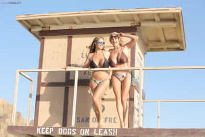 Busty bikini babes Eva Notty & Kelly Madison sun their big tits at the beach