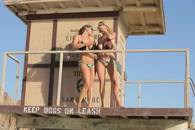 Busty bikini babes Eva Notty & Kelly Madison sun their big tits at the beach