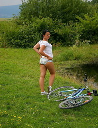 Brunette amateur rubs her shiny on top twat against bike frame after riding fond of woods