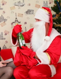 Blonde teen Oksana shares a bottle of wine with Santa before anal sex
