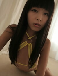 slurpt luxe Aziatische donker haren model poseren in geel Bikini voor pesten Bever